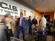 Personnel from the Naval Criminal Investigation Services talk with crew from CBS' NCIS television series while visiting the set in California.