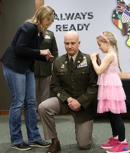 Rachal and Rosalyn Roach, the family of newly promoted Col. Bradley Roach, secure new rank on his uniform during a promotion ceremony March 20 at the Illinois Military Academy, Camp Lincoln in Springfield.