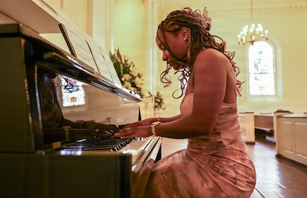 U.S. Army Spc. Aaralyn Mills, a patrol team lead with Joint Task Force - District of Columbia, plays piano before a fellow Indiana National Guard member's wedding at the Old Post Chapel on Fort Myer, Virginia, March 21, 2026. About 2,700 National Guard members support the D.C. Safe and Beautiful mission, assisting the Metropolitan Police Department in maintaining public safety for residents, commuters and visitors throughout the District.