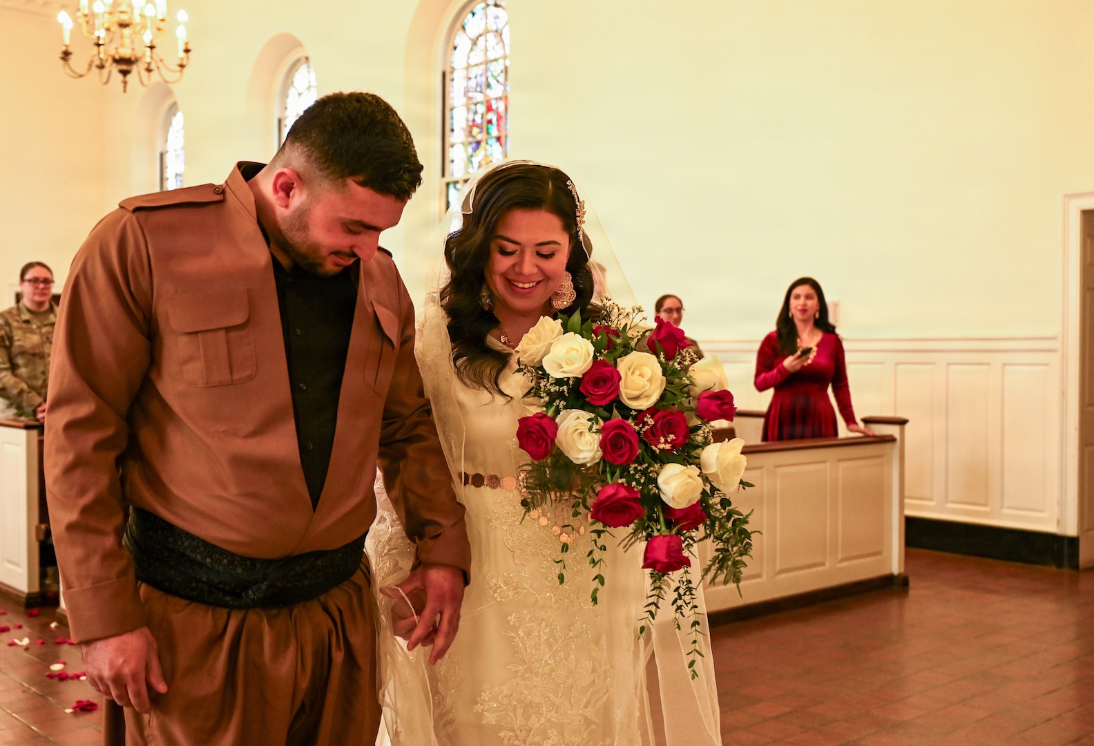 U.S. Army Spc. Ester Henriquez, an Indiana National Guard member assigned to Joint Task Force - District of Columbia, holds Hasan Alpkan's hand during their wedding ceremony at the Old Post Chapel on Fort Myer, Virginia, March 21, 2026. About 2,700 National Guard members support the D.C. Safe and Beautiful mission, assisting the Metropolitan Police Department in maintaining public safety for residents, commuters and visitors throughout the District.