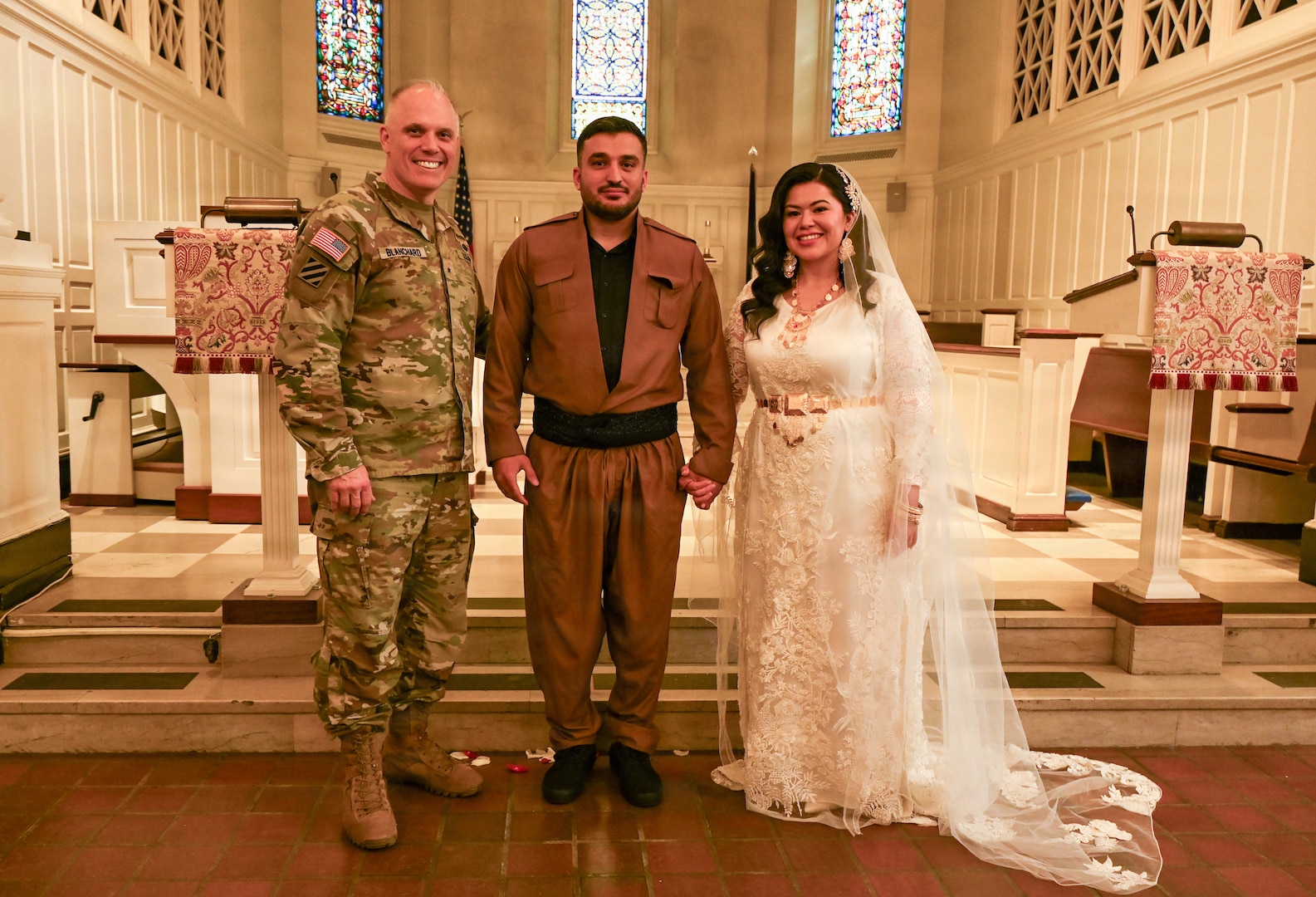 U.S. Army Brig. Gen. Leland D. Blanchard II, Commanding General (interim) of the District of Columbia National Guard, Hasan Alpkan and Spc. Ester Henriquez, an Indiana National Guard member assigned to Joint Task Force - DC, pose for a photo after their wedding ceremony at the Old Post Chapel on Fort Myer, Virginia, March 21, 2026. About 2,700 National Guard members support the D.C. Safe and Beautiful mission, assisting the Metropolitan Police Department in maintaining public safety for residents, commuters and visitors throughout the District.