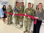 A group of Soldiers and civilians line up to cut the ribbon on the AFWC.