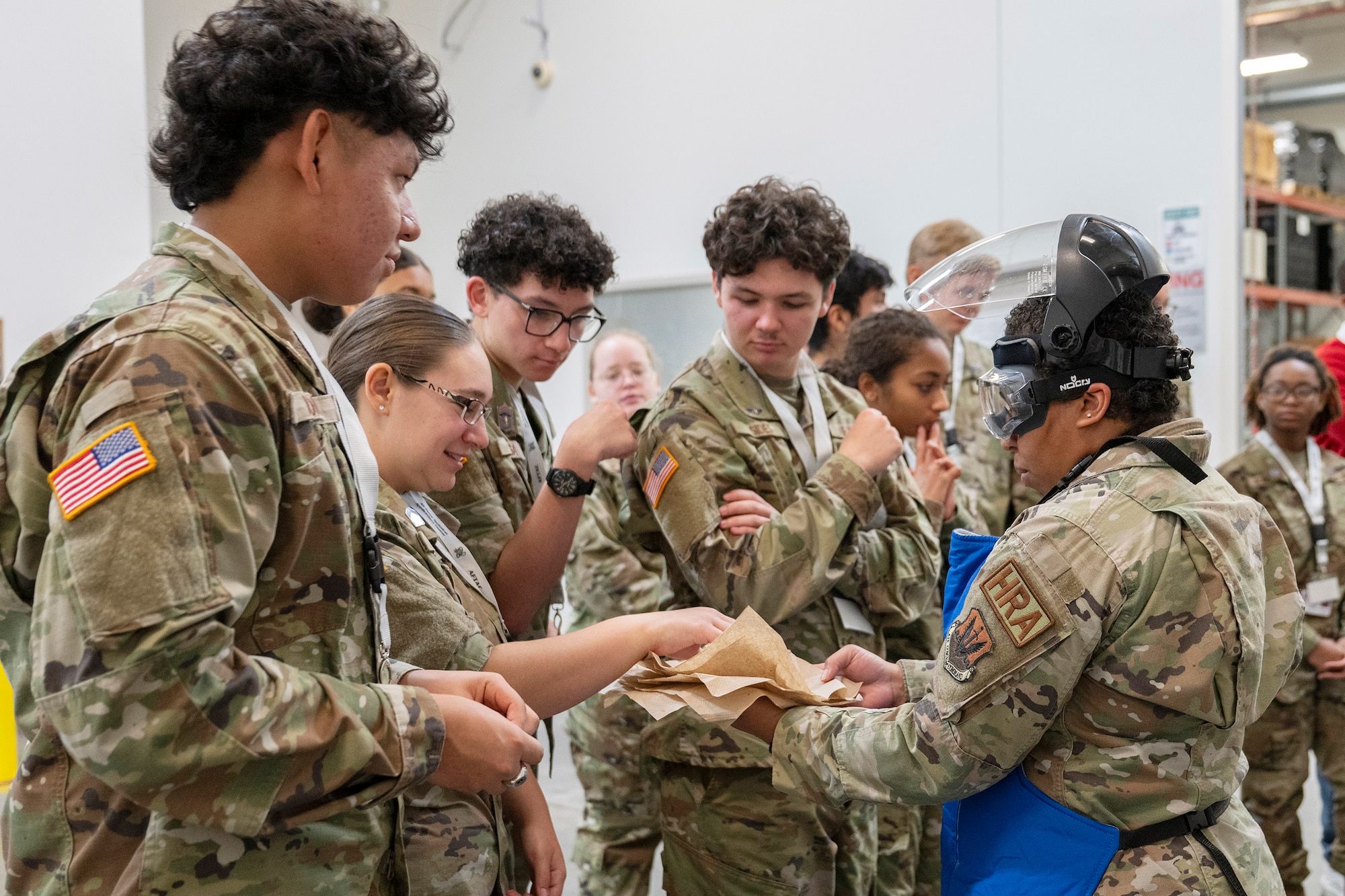 Senior Airman Elizabeth Lopez (right), a human resource administrator at the Air Force Technical Applications Center, Patrick Space Force Base, Fla., demonstrates the effects of liquid nitrogen on gummy bears to a group of Junior Reserve Officer Training School Cadets from Vero Beach High School Fla., March 17, 2026.   (U.S. Air Force photo by Matthew S. Jurgens)