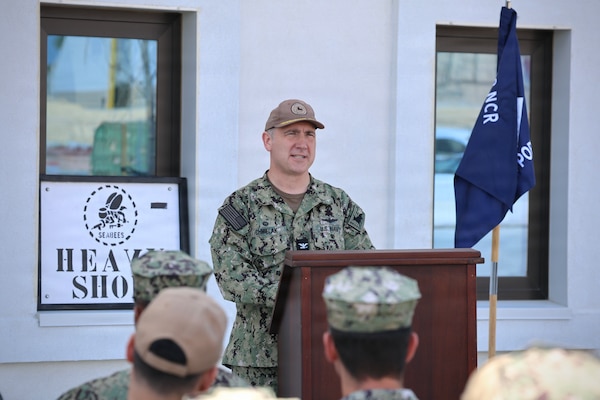 Capt. Chmielak stands at a podium and gives a speech in uniform.