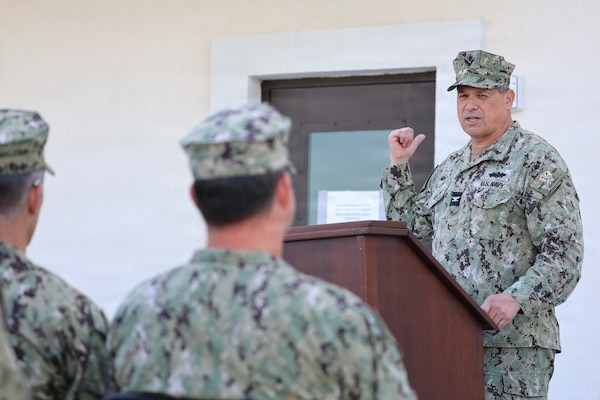 Capt. Willey points to a new building during a speech in uniform.