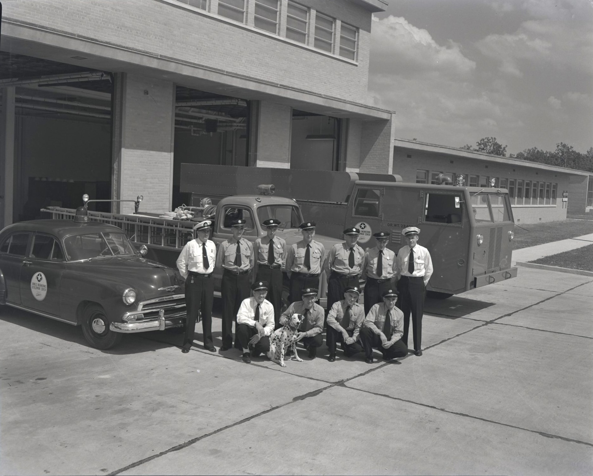 11 AEDC Firemen with fire dog outside Fire Station