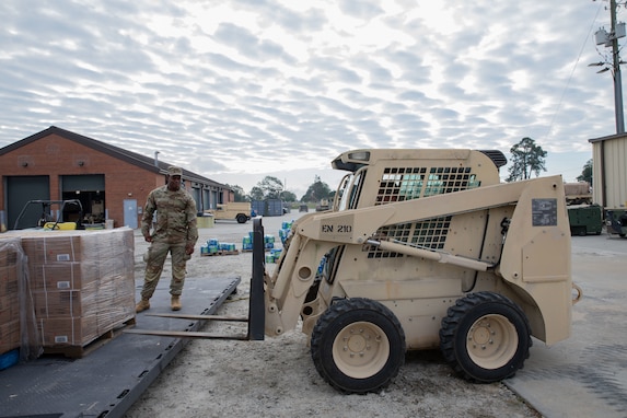 U.S. Army Pfc. Enric Jones, a horizontal construction engineer with the Columbus-based 876th Engineer Support Company, 878th Engineer Battalion, 648th Maneuver Enhancement Brigade, Georgia Army National Guard, directs a Light Type III Skid Steer Loader in Augusta, Georgia, Sept. 29, 2024. The Georgia National Guard is providing response and recovery support to areas impacted by Hurricane Helene. The Georgia Emergency Management and Homeland Security Agency (GEMA/HS) is the lead agency. We will continue to partner with GEMA/HS as well as other local, state, and federal entities at the direction of the Governor. (U.S. Army National Guard photo by Sgt. Fernanda Olivas)