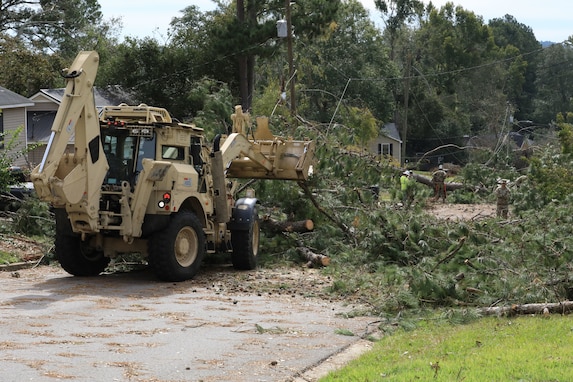U.S. Army Soldiers with the Augusta-based Headquarters and Headquarters Company, 878th Engineer Battalion, 648th Maneuver Enhancement Brigade, Georgia Army National Guard, remove fallen trees from a road using a high mobility engineer excavator (HMEE) in Martinez, Georgia Oct. 1, 2024. The Georgia National Guard has mobilized to provide response and recovery support to areas in the state impacted by Hurricane Helene. At the direction of the Governor and through The Georgia Emergency Management and Homeland Security Agency (GEMA/HS), the Georgia National Guard will continue to partner local, state, and federal entities in this effort. (U.S. Army National Guard photo by Spc. Kemarvo Smith)