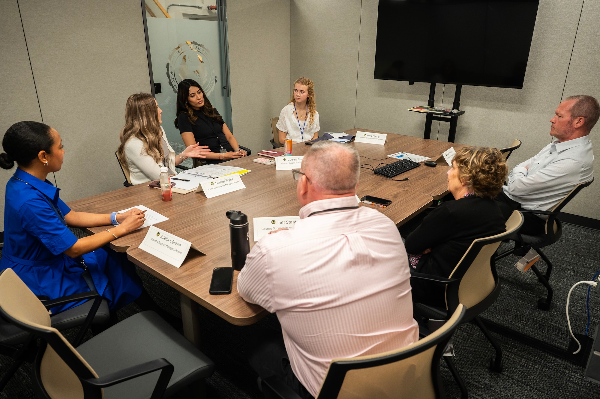 Individuals sit around conference table.