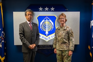 Man and female Air Force officer stand in front of sign that says Air Force Life Cycle Management Center.