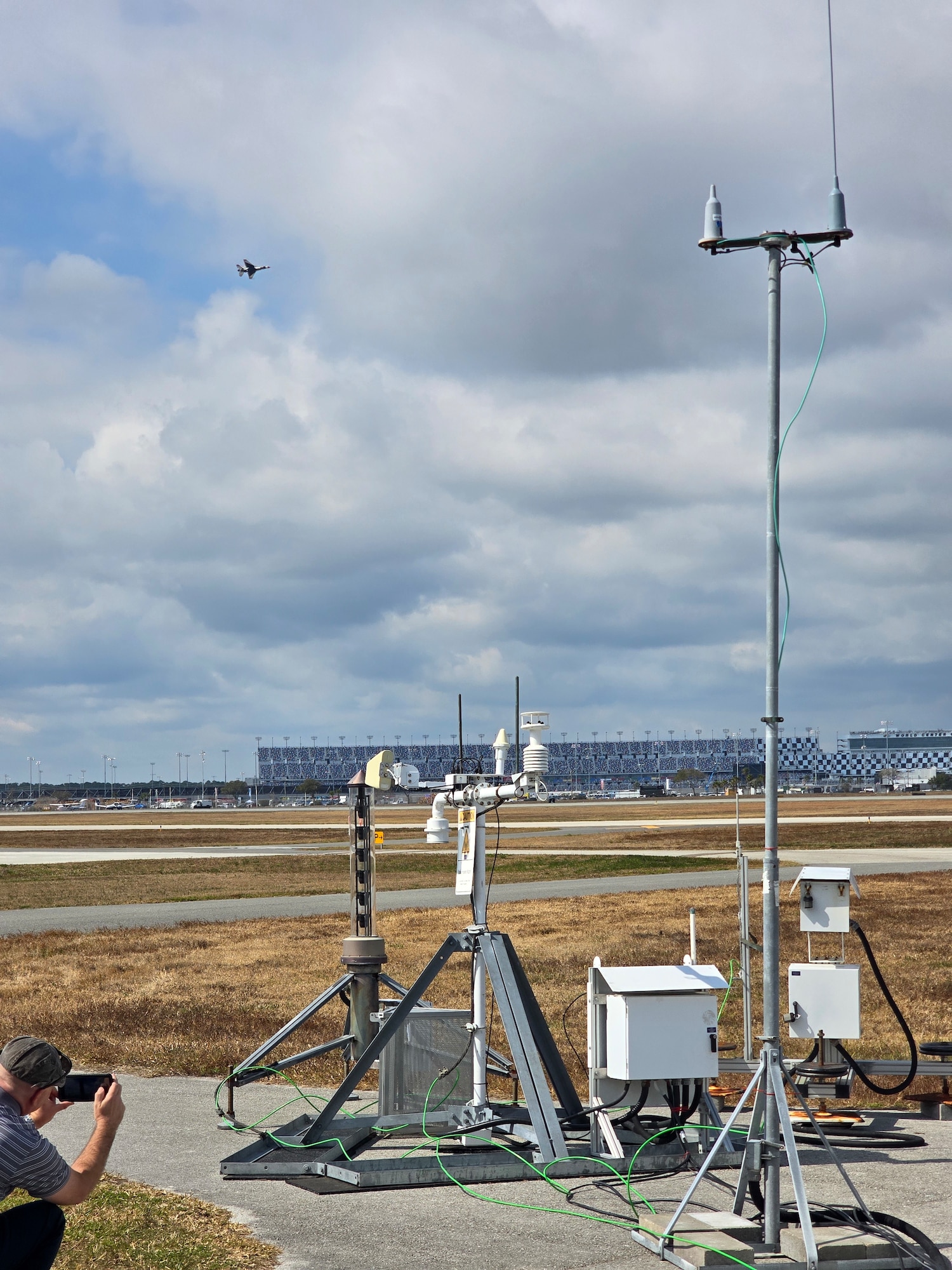 Michael Kaul, Deputy Program Manager for Systems Development Directorate at the Air Force Technical Applications Center, Patrick Space Force Base, Fla., records a U.S. Air Force Thunderbird F-16 as it flies above the Daytona International Speedway adjacent to the Daytona Beach International Airport Feb. 15, 2026.  The Thunderbirds were performing at the 2026 Daytona 500 NASCAR Cup Series, and Kaul and his team deployed the U.S. Prompt Diagnostics System’s new mobile capability to test it in a real-world, high visibility setting in support of National Technical Nuclear Forensics readiness.  (Courtesy photo)