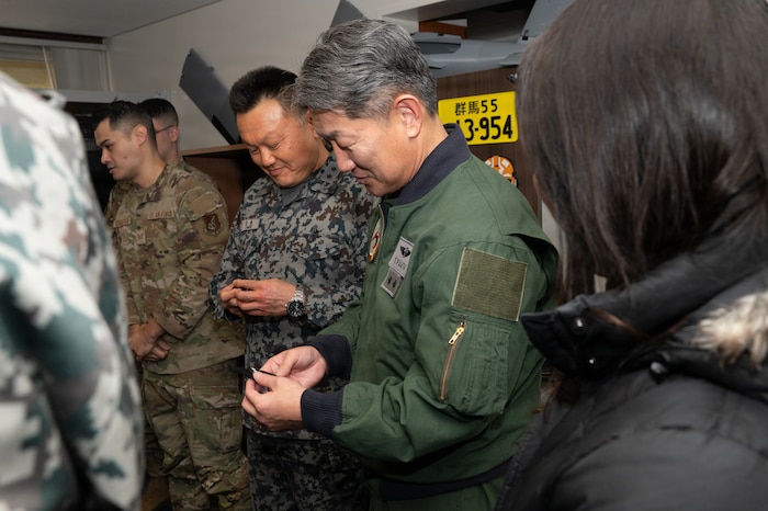 Japan Air Self-Defense Force (JASDF) Maj. Gen. Teruaki Fujita, 3rd Air Wing commander, reviews 3D printed products during a Chief of Staff of the Air Force Strategic Studies Group tour at Misawa Air Base.