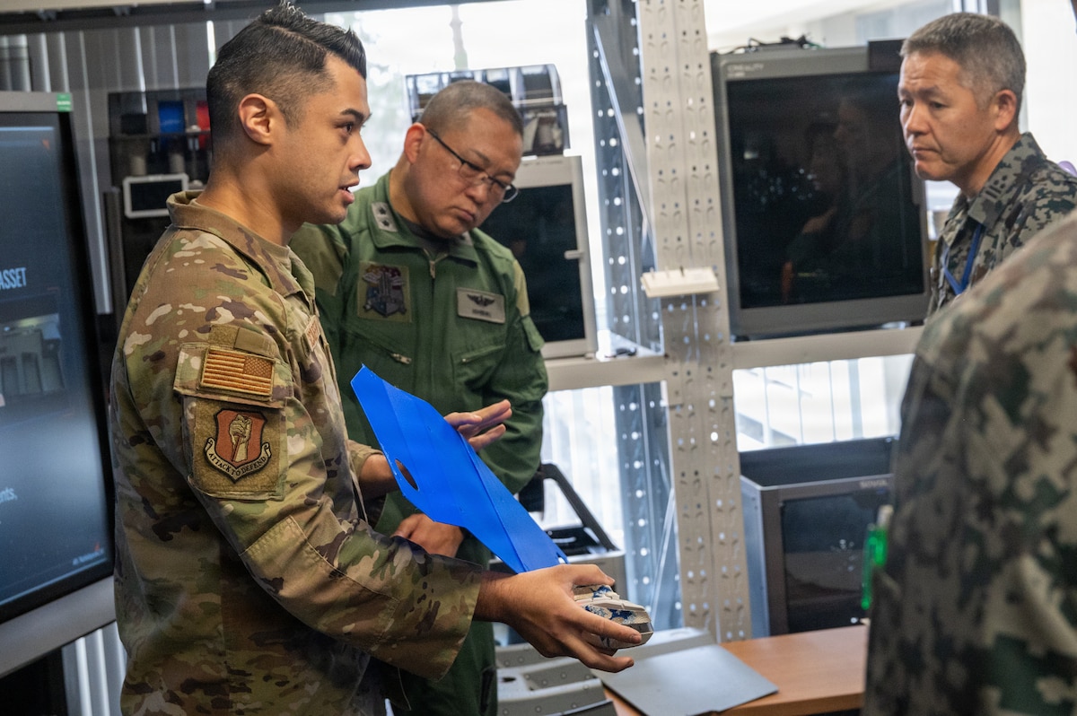 U.S. Air Force Tech Sgt. Andrew Schaeffer, 35th Fighter Wing Staff Agency Innovation Cell director, briefs Japan Air Self-Defense Force leaders on 3-D printing techniques during a Chief of Staff of the Air Force Strategic Studies Group tour at Misawa Air Base