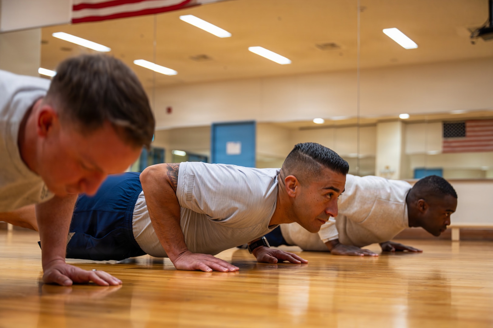 U.S. Air Force Chief Master Sergeants Cole Reinbold, 36th Airlift Squadron senior enlisted leader, Carlos Damian, U.S. Forces Japan command senior enlisted leader, and Senior Master Sgt. Lonnie Sapp, U.S. Forces Japan J33 current operations senior enlisted leader, perform push-ups during a diagnostic physical fitness readiness assessment at Yokota Air Base, Japan, March 11, 2026.