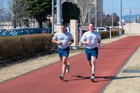 U.S. Air Force Chief Master Sergeants Carlos Damian (left), U.S. Forces Japan command senior enlisted leader, and Cole Reinbold, 36th Airlift Squadron SEL, perform a two-mile run during a diagnostic physical fitness readiness assessment at Yokota Air Base, Japan, March 11, 2026.