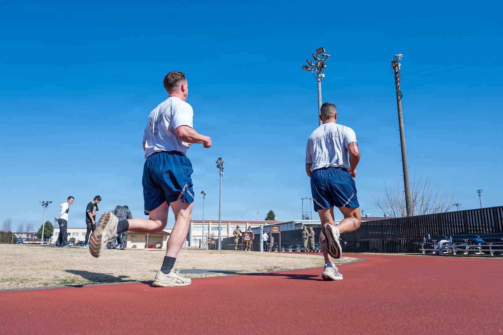 U.S. Air Force Chief Master Sergeants Cole Reinbold (left), 36th Airlift Squadron SEL, and Carlos Damian, U.S. Forces Japan command senior enlisted leader, perform a two-mile run during a diagnostic physical fitness readiness assessment at Yokota Air Base, Japan, March 11, 2026.
