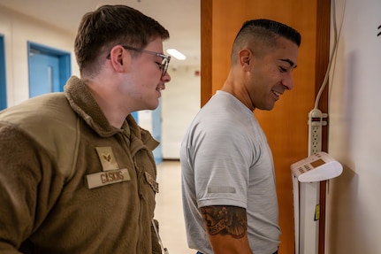 U.S. Air Force Chief Master Sgt. Carlos Damian, U.S. Forces Japan command senior enlisted leader, weighs in with Senior Airman Mason Gaskins, 374th Force Support Squadron sports and fitness shift leader, during a diagnostic physical fitness readiness assessment at Yokota Air Base, Japan, March 11, 2026.