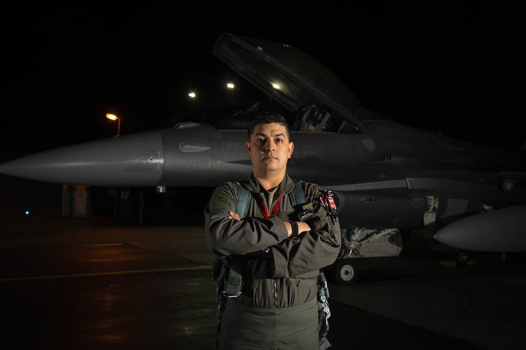 U.S. Air Force Maj. Michael Blea, 480th Fighter Squadron F-16 Fighting Falcon pilot, poses for a photo in front of a fighter jet at Spangdahlem Air Base, Germany, Dec. 10, 2025.