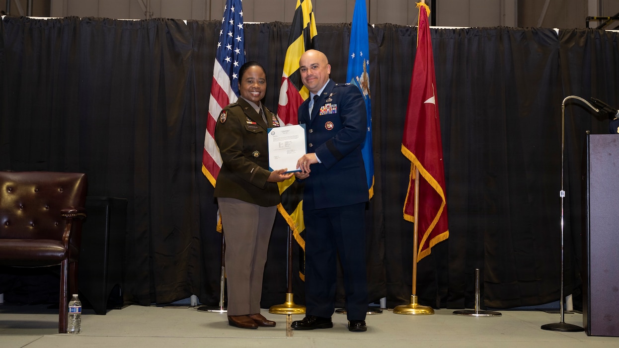 Maryland Army National Guard Maj. Gen. Janeen Birckhead, adjutant general for Maryland, presents a certificate of promotion to Maryland Air National Guard Col. Joed Carbonell-López, commander of the 175th Wing, during a ceremony at Warfield Air National Guard Base at Martin State Airport, Maryland, March 22, 2026. Carbonell-López was promoted to brigadier general and recognized for his career of many achievements. (U.S. Air National Guard photo by Staff Sgt. Alexandra Huettner)