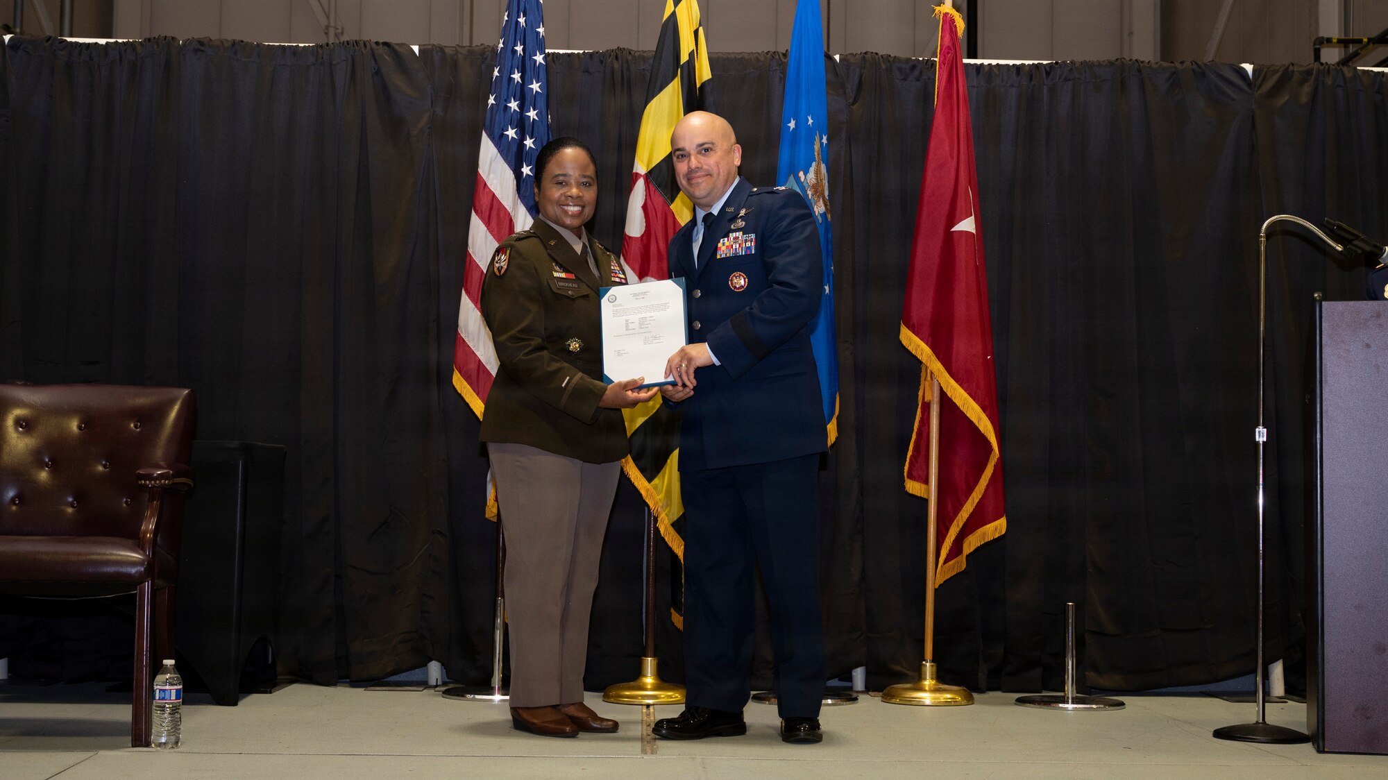 Maryland Army National Guard Maj. Gen. Janeen Birckhead, adjutant general for Maryland, presents a certificate of promotion to Maryland Air National Guard Col. Joed Carbonell-López, commander of the 175th Wing, during a ceremony at Warfield Air National Guard Base at Martin State Airport, Maryland, March 22, 2026. Carbonell-López was promoted to brigadier general and recognized for his career of many achievements. (U.S. Air National Guard photo by Staff Sgt. Alexandra Huettner)