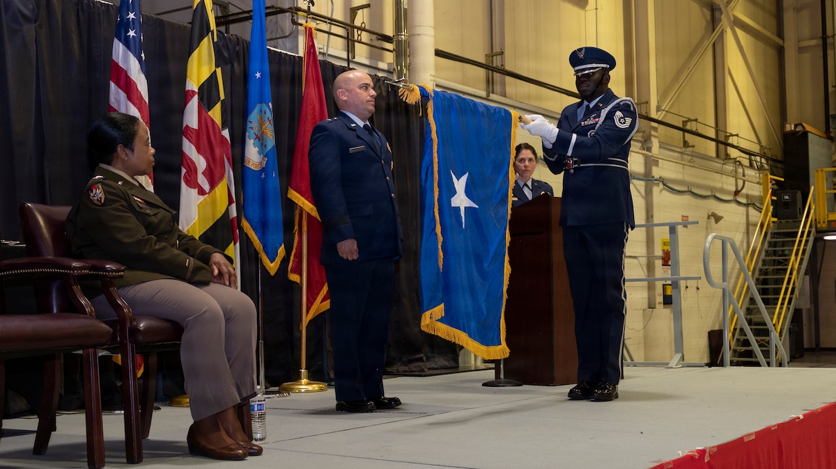 Maryland Air National Guard Col. Joed Carbonell-López, commander of the 175th Wing, stands during his flag unfurling and is promoted to brigadier general by Maryland Army National Guard Maj. Gen. Janeen Birckhead, adjutant general for Maryland, during a ceremony at Warfield Air National Guard Base at Martin State Airport, Maryland, March 22, 2026. In his role as wing commander, Carbonell-López oversees more than 1,400 personnel across three operations groups, one mission support group, one medical group, and one civil engineering element. (U.S. Air National Guard photo by Staff Sgt. Alexandra Huettner)