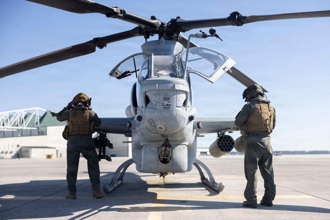 U.S. Marine Corps Capt. William A. Hart, from New Jersey, left, and Capt. Colin Kennelly, from Connecticut, both AH-1Z Viper pilots with Marine Light Attack Helicopter Squadron (HMLA) 167, Marine Aircraft Group 29, 2nd Marine Aircraft Wing, prepare to enter an AH-1Z Viper at Marine Corps Air Station New River, North Carolina, March 20, 2026. HMLA-167 is one of two Marine light attack helicopter squadrons assigned to 2nd MAW. 2nd MAW generates, deploys and sustains expeditionary, combat-ready units to provide flexible and responsive aviation support to combatant commander presence, security cooperation, and crisis-response. (U.S. Marine Corps photo by Lance Cpl. Perri Wood)