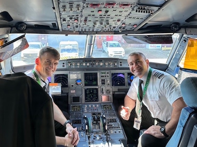 Georgia Army National Guard pilots Chief Warrant Officer 2 Ryan Jones and Warrant Officer Austin Scales from the Marietta-based 78th Aviation Troop Command, pose in the cock pit of a Frontier Airlines Airbus 320.