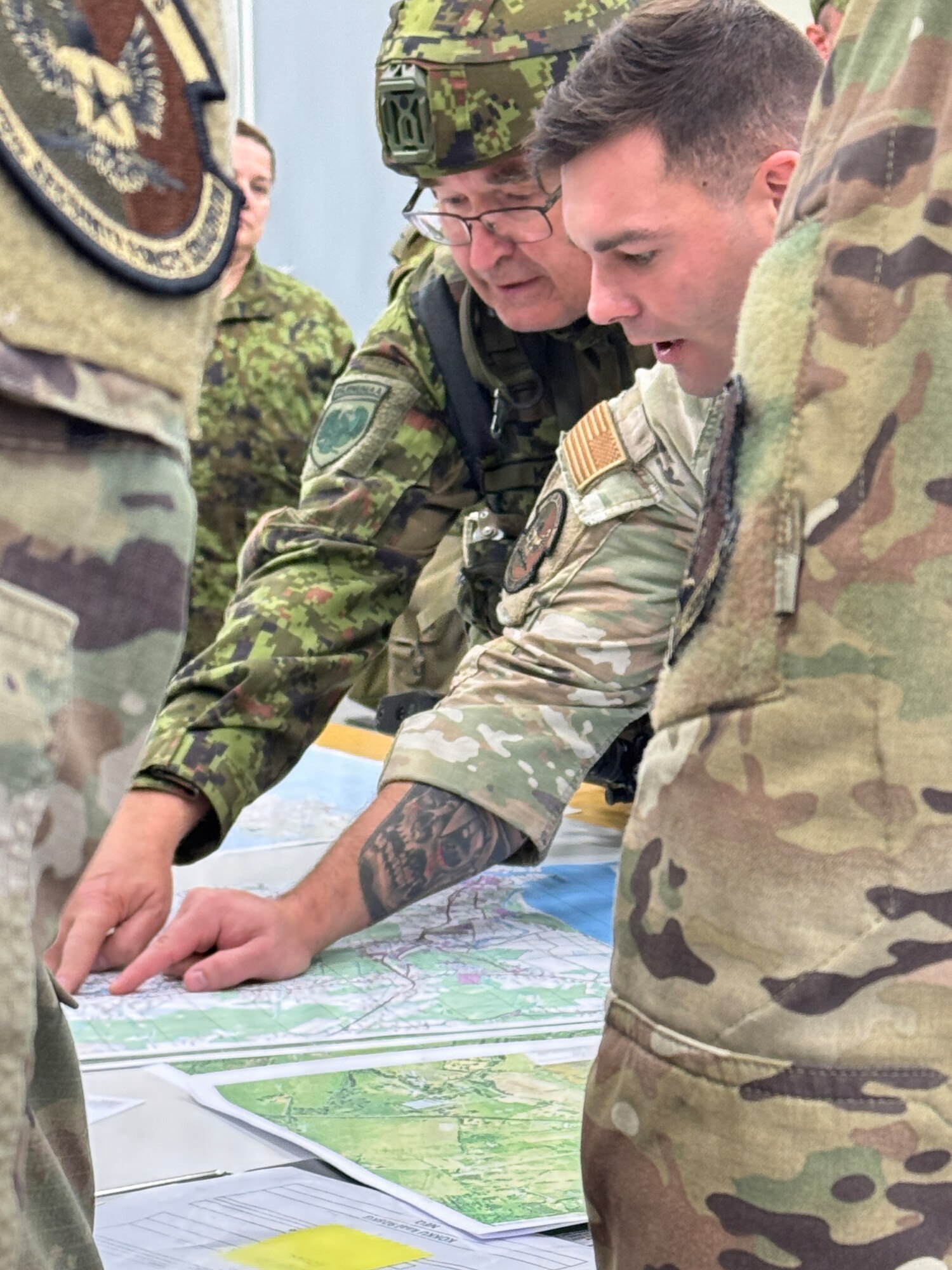 Maryland Air National Guard Staff Sgt. William Marion, combat arms instructor for the 175th Security Forces Squadron, speaks with a member of the Estonian Defense League while pointing at a map in Pärnu, Estonia, September 26, 2025. Members shared best practices with EDL soldiers to test the mobilization defense plan while utilizing convoy operations  as part of Exercise Hurricane, which included participants from Estonia, Latvia, France and the U.K. (Courtesy Photo)