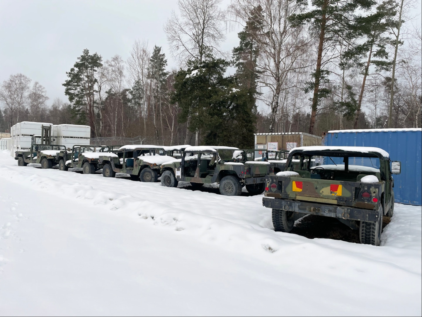Older Humvees sitting outside in the snow