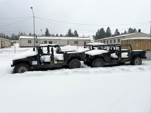 Older Humvees sitting outside in the snow