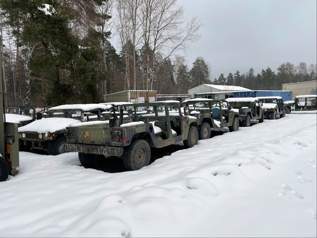 Older Humvees sitting outside in the snow