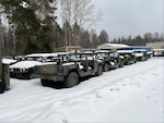 Older Humvees sitting outside in the snow