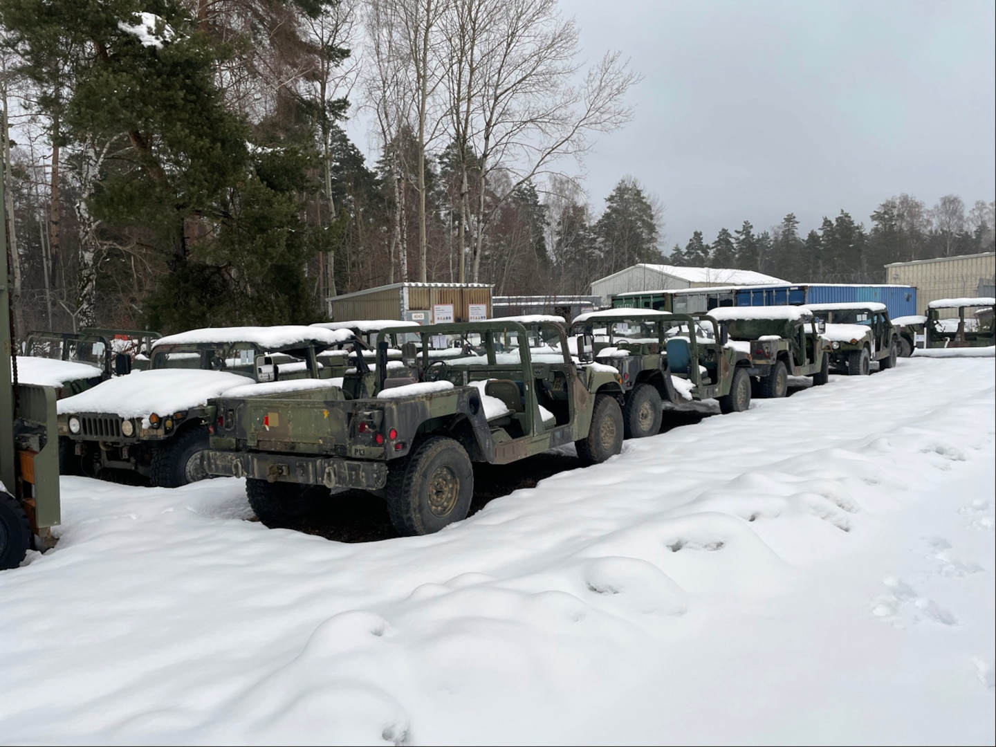Older Humvees sitting outside in the snow