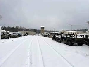 Older Humvees sitting outside in the snow