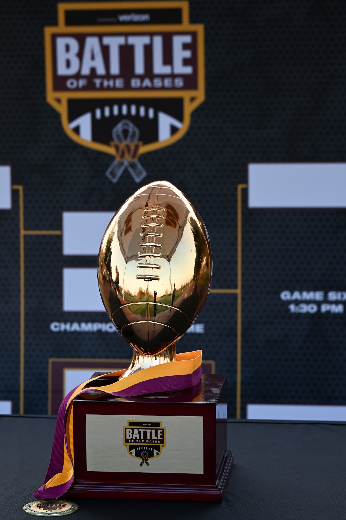 The Battle of the Bases flag football tournament trophy is displayed in front of the tournament bracket.