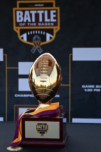 The Battle of the Bases flag football tournament trophy is displayed in front of the tournament bracket.