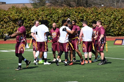 Participants from Joint Base Myer-Henderson Hall and Naval Support Facility Indian Head shake hands after a game at the Battle of the Bases flag football tournament.