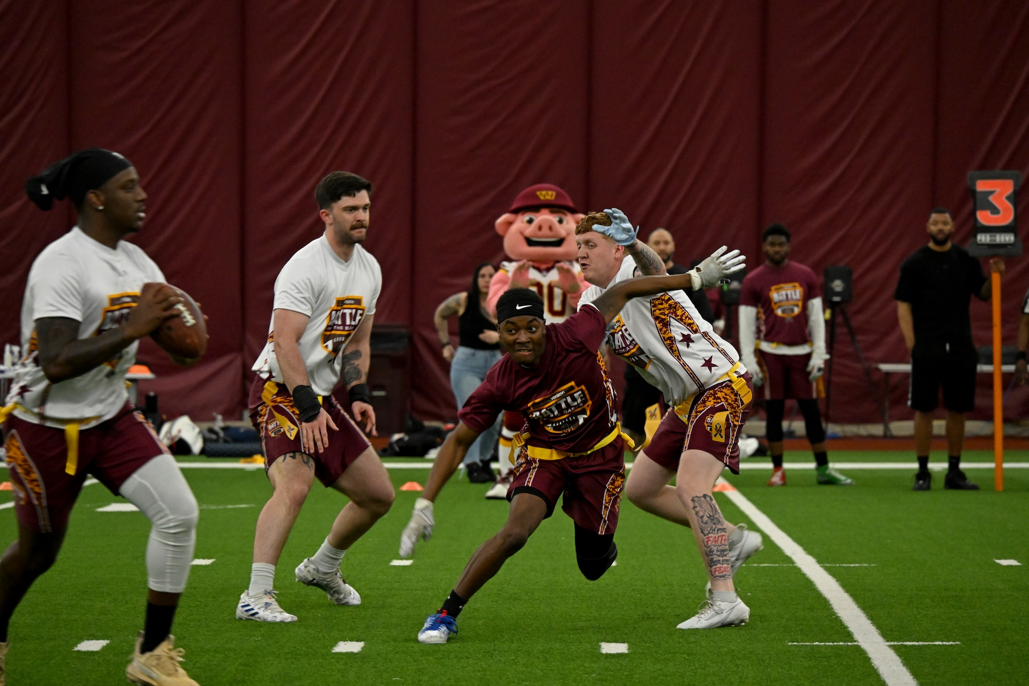 An athlete from Joint Base Andrews breaks through the line to reach the quarterback at the Battle of the Bases flag football tournament.