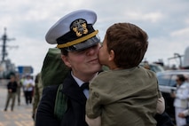 NAVAL STATION NORFOLK, Va. (March 23, 2026) Lt. Cmdr. Jessica Fonseca, a Sailor assigned to the Ticonderoga-class guided-missile cruiser USS Gettysburg (CG 64), embraces a family member following the ship's return to Naval Station Norfolk, March 23, after five months supporting U.S. Southern Command missions. Gettysburg is a multi-mission guided-missile cruiser capable of air warfare, undersea warfare, naval surface fire support and surface warfare, supporting carrier battle groups, amphibious forces or operating independently and as flagships of surface action groups. (U.S. Navy photo by Mass Communication Specialist 1st Class Anderson W. Branch)