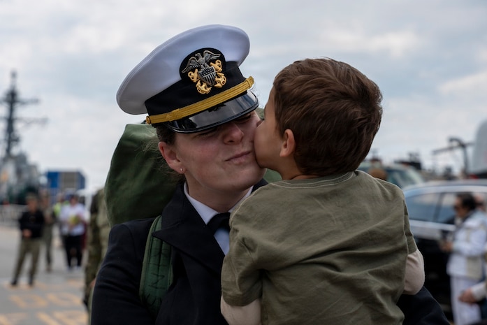 NAVAL STATION NORFOLK, Va. (March 23, 2026) Lt. Cmdr. Jessica Fonseca, a Sailor assigned to the Ticonderoga-class guided-missile cruiser USS Gettysburg (CG 64), embraces a family member following the ship's return to Naval Station Norfolk, March 23, after five months supporting U.S. Southern Command missions. Gettysburg is a multi-mission guided-missile cruiser capable of air warfare, undersea warfare, naval surface fire support and surface warfare, supporting carrier battle groups, amphibious forces or operating independently and as flagships of surface action groups. (U.S. Navy photo by Mass Communication Specialist 1st Class Anderson W. Branch)