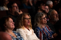 Audience members watch a concert.