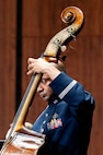 An Airman plays the bass, the neck covers part of his face.