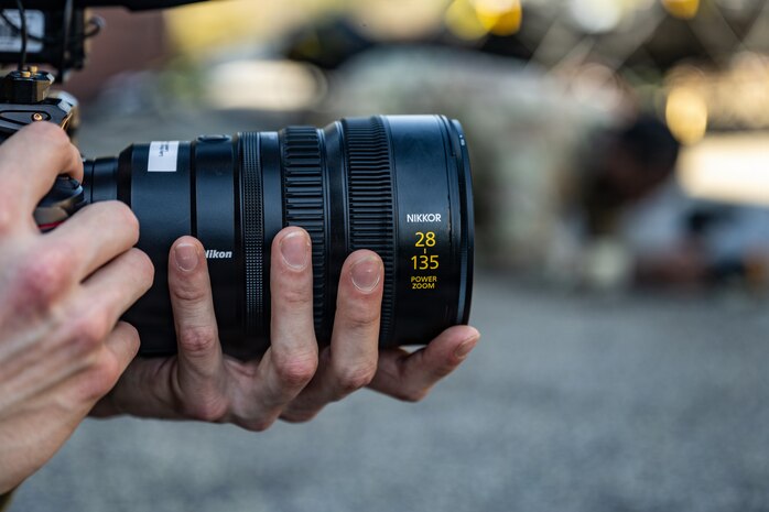 Hands hold a camera facing the right.