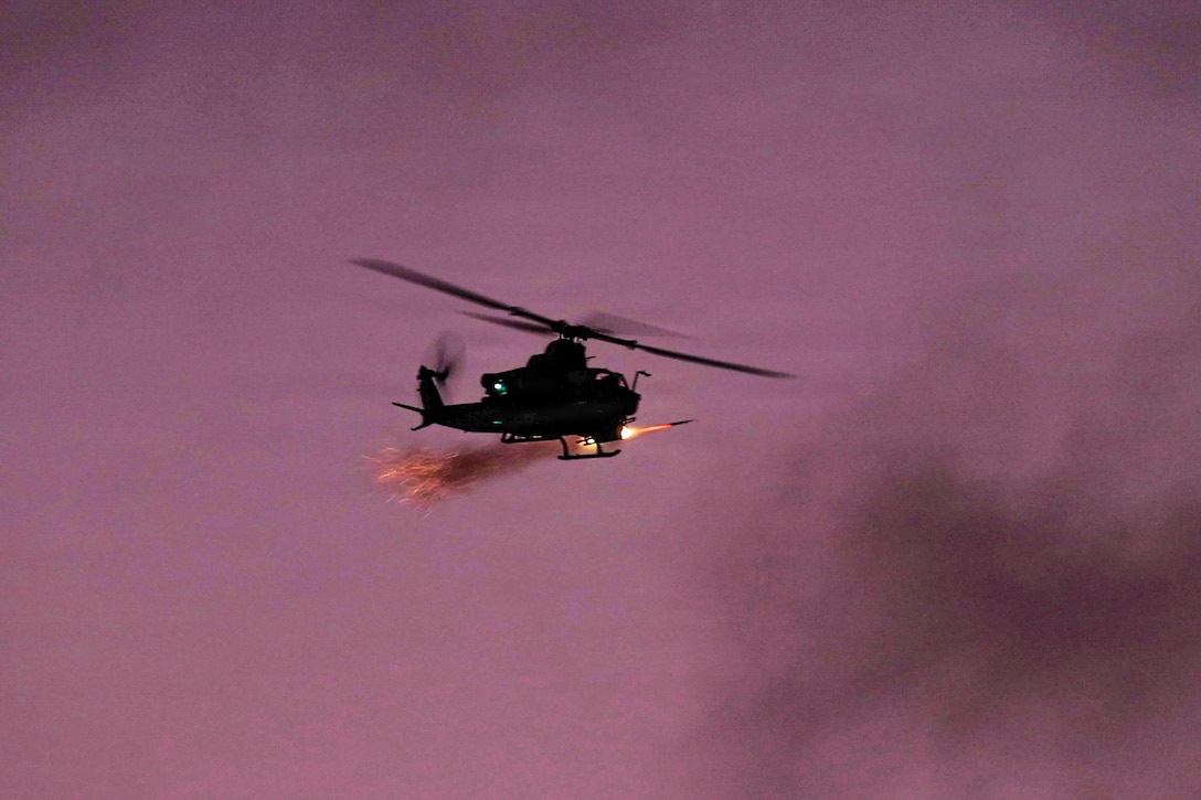A projectile shoots from a flying helicopter, creating a trail of flames in a cloudy purplish sky.