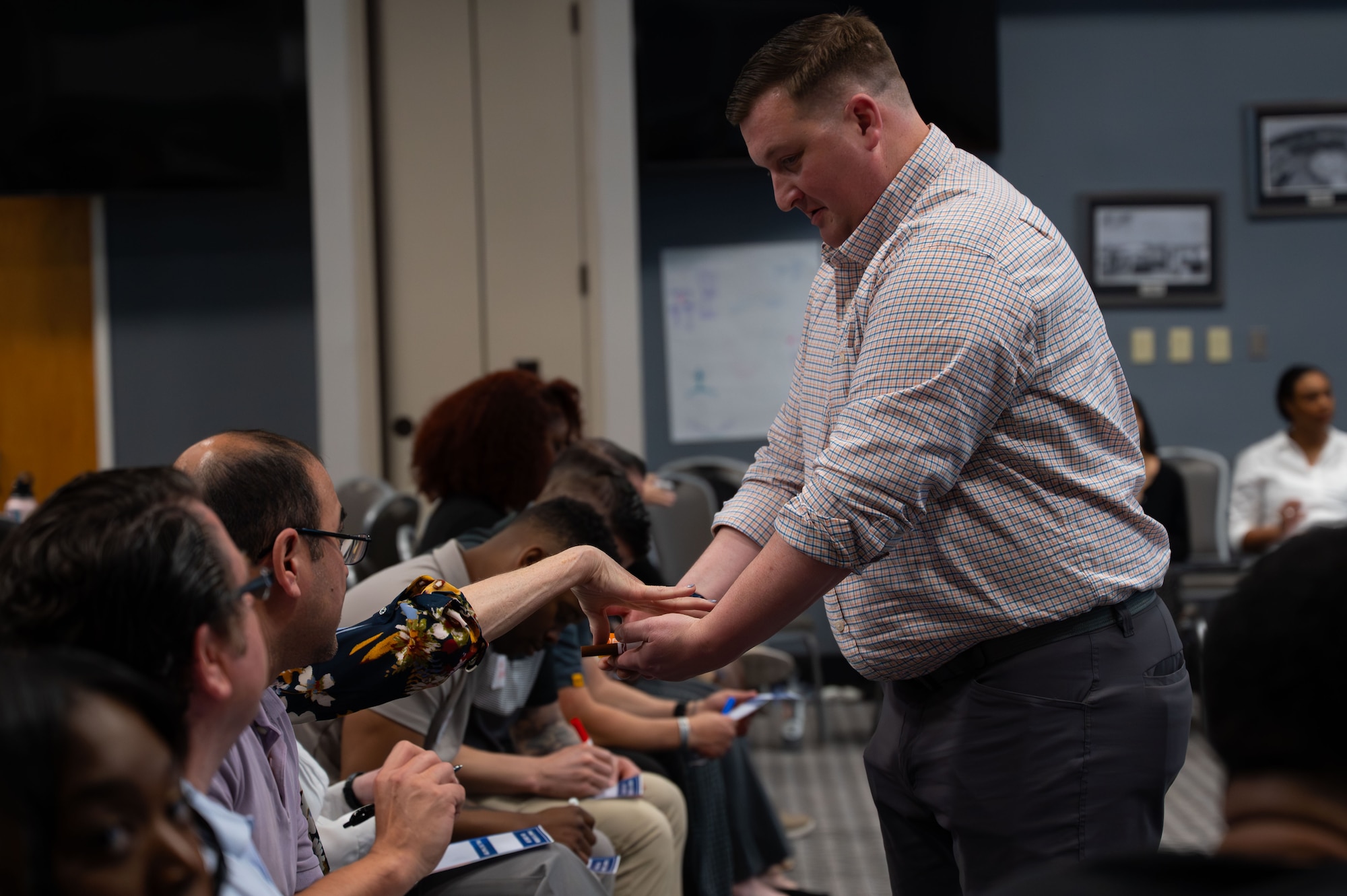 Wingman Guardian Connect course participants distribute pens for their next activity.