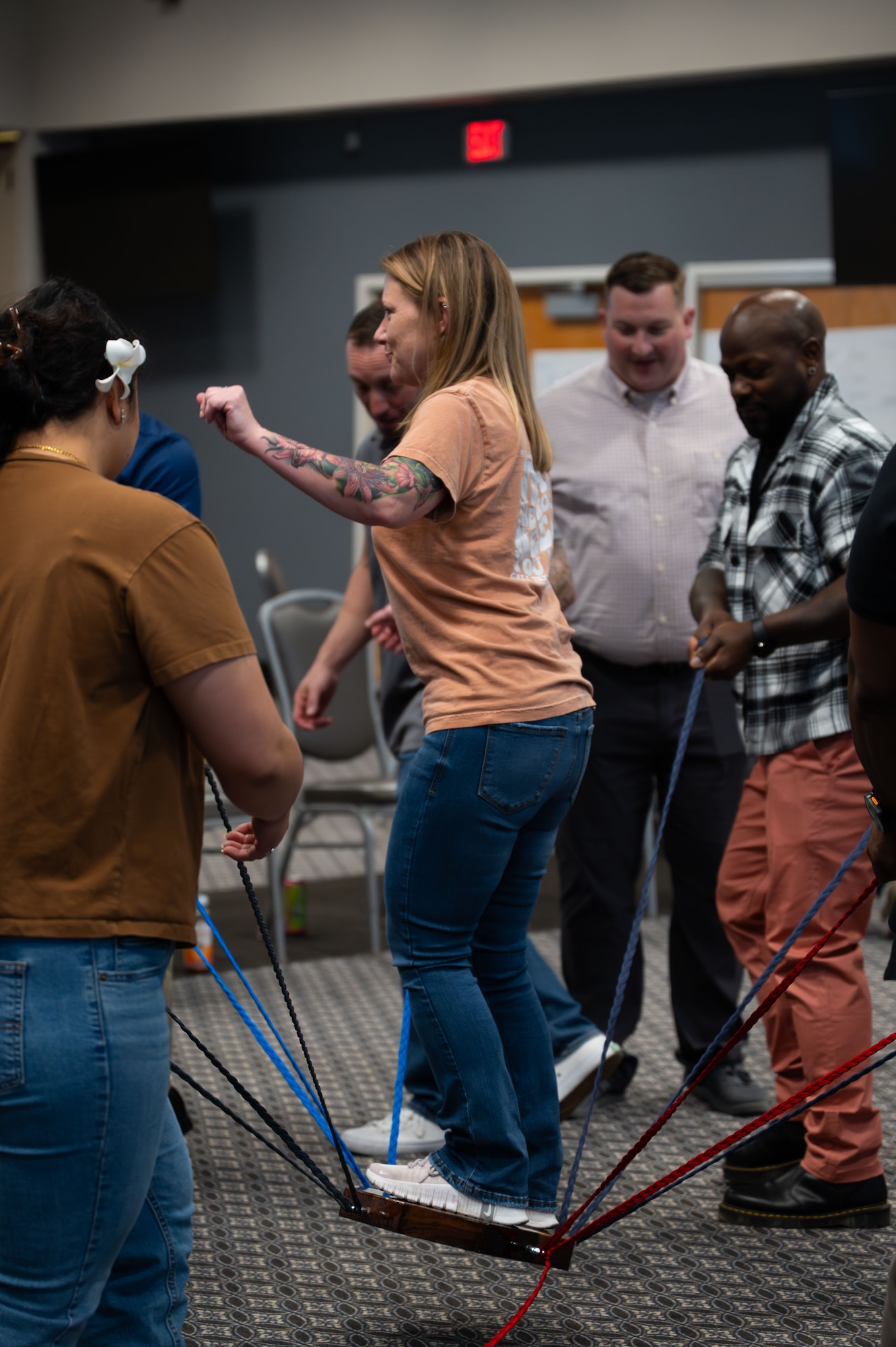 Wingman Guardian Connect course participants do an activity that includes balancing a person by pulling ropes.