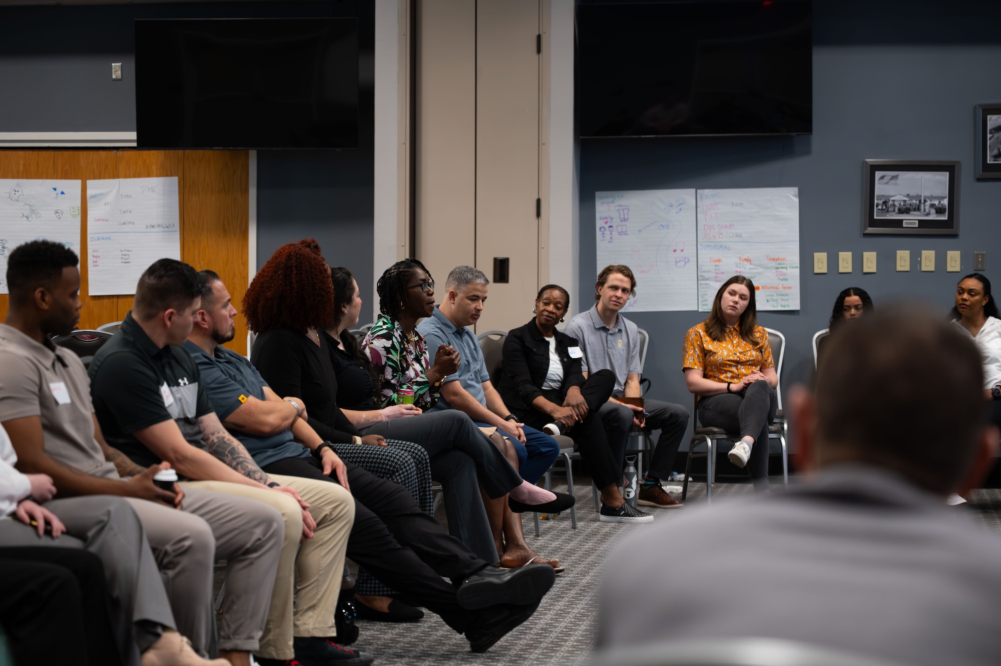 Wingman Guardian Connect course participants sit in a circle and discuss their group activities.