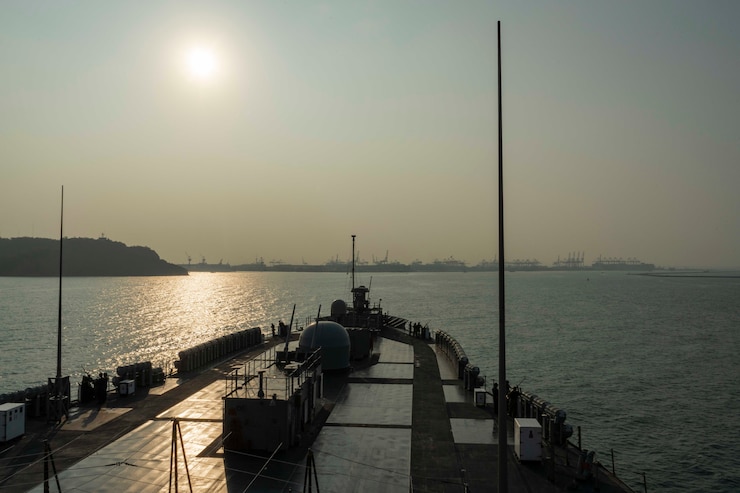 A photo of a boat on the river with the sun in a haze in the sky. 
