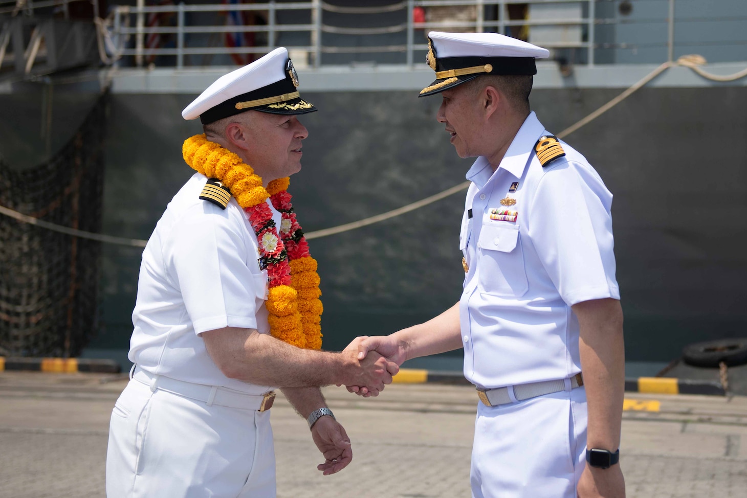 U.S. Navy Capt. Louis F. Catalina, commanding officer of U.S. 7th Fleet flagship USS Blue Ridge (LCC 19), left, is greeted by Capt. Kittipan Chaisiridham, commanding officer, HTMS Similan (871), right, during an arrival ceremony in Laem Chabang, Thailand, March 26, 2026.