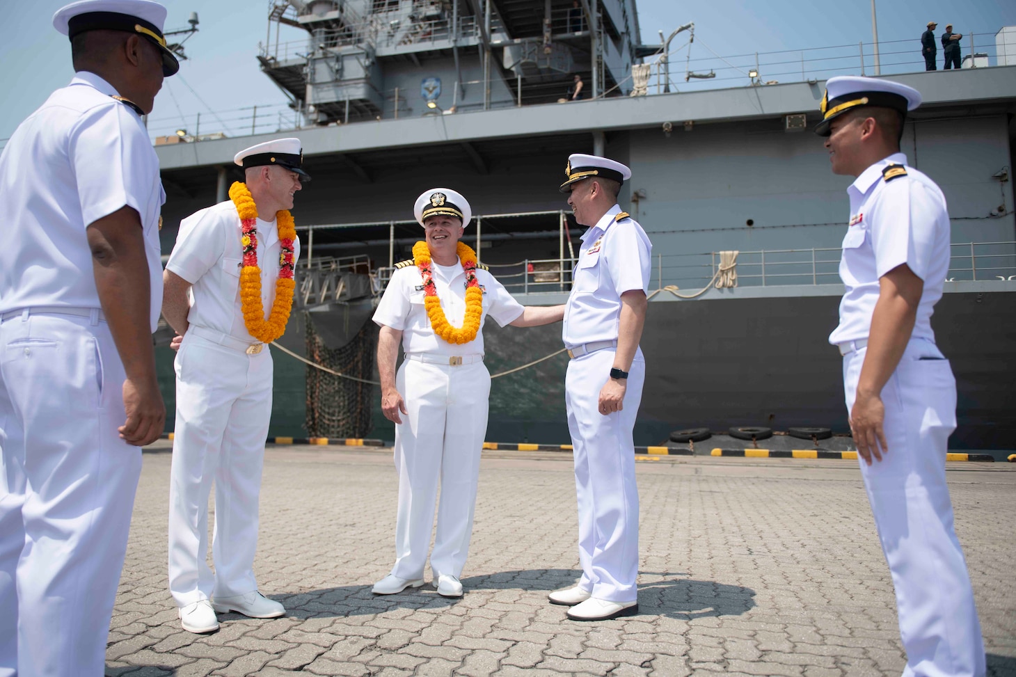 U.S. Navy Capt. Louis F. Catalina, commanding officer, U.S. 7th Fleet flagship USS Blue Ridge (LCC 19), center, is greeted by Capt. Kittipan Chaisiridham, commanding officer, HTMS Similan (871), and other Royal Thai Navy officers during an arrival ceremony in Laem Chabang, Thailand, March 26, 2026.
